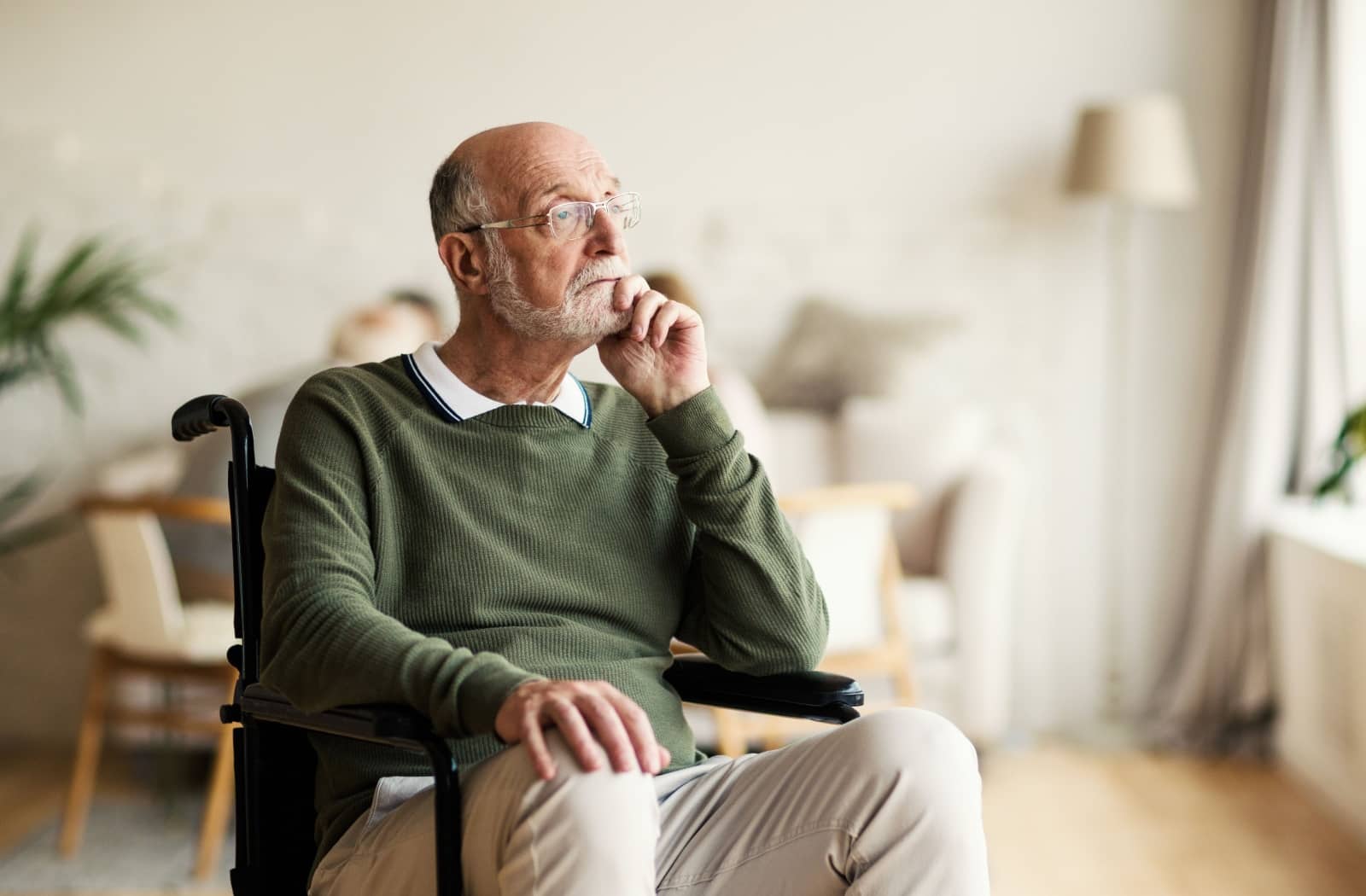 An older adult lost in thought and blankly staring ahead.